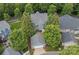 Aerial view of home, lush landscaping, garage and private outdoor patio with seating at 15830 Waterfront Dr, Huntersville, NC 28078