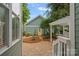 Backyard showing garden with bright yellow door and a pergola sitting on a brick patio at 15830 Waterfront Dr, Huntersville, NC 28078