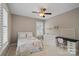 Cozy bedroom with a ceiling fan, a window with white shutters, and a functional desk area at 15830 Waterfront Dr, Huntersville, NC 28078