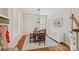 Bright dining room with hardwood floors, white wainscoting, modern chandelier, and large windows with plantation shutters at 15830 Waterfront Dr, Huntersville, NC 28078