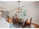 Dining area featuring wood table set, modern chandelier and large windows with plantation shutters at 15830 Waterfront Dr, Huntersville, NC 28078