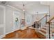 Welcoming entryway featuring hardwood floors, coat rack and stairway leading to upper level at 15830 Waterfront Dr, Huntersville, NC 28078