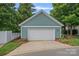 Detached two-car garage with white door and teal siding surrounded by lush landscaping at 15830 Waterfront Dr, Huntersville, NC 28078