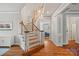 Open staircase featuring hardwood steps, white risers, and elegant chandelier at 15830 Waterfront Dr, Huntersville, NC 28078