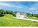 Side view of the home with an ample driveway, large lawn space, and surrounding trees at 164 Vance Farm Dr, Statesville, NC 28625