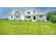 Inviting two-story home featuring a stone and white exterior, front porch, and beautiful lawn at 164 Vance Farm Dr, Statesville, NC 28625