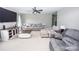 Cozy living room with plush gray sofas, a modern ceiling fan, and a large entertainment center at 164 Vance Farm Dr, Statesville, NC 28625