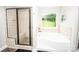 This modern main bathroom features a tiled shower, garden tub, and a large window overlooking the yard at 164 Vance Farm Dr, Statesville, NC 28625