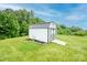 Backyard storage shed or outbuilding featuring white siding and black trim in a grassy yard at 164 Vance Farm Dr, Statesville, NC 28625