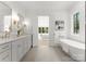 Elegant bathroom featuring a freestanding tub, double vanity with gold fixtures and a view to the main bedroom at 20000 Schooner Dr, Cornelius, NC 28031