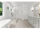 Bright bathroom featuring a glass-enclosed shower, soaking tub, and a modern vanity with elegant gold fixtures at 20000 Schooner Dr, Cornelius, NC 28031