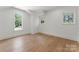 Unfurnished bedroom with hardwood floors, trim, and two windows that provide natural light at 20000 Schooner Dr, Cornelius, NC 28031