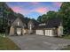 Stunning exterior featuring a modern design with stone accents, three-car garage, and a spacious driveway at 20000 Schooner Dr, Cornelius, NC 28031