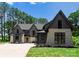 Beautiful home exterior showcasing a mix of stone and siding, complemented by lush landscaping and a manicured lawn at 20000 Schooner Dr, Cornelius, NC 28031