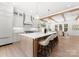 Bright, spacious kitchen with a large island, white cabinetry, and modern pendant lighting over hardwood floors at 20000 Schooner Dr, Cornelius, NC 28031