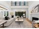 Open-concept living room featuring a fireplace, hardwood floors, a two-story ceiling and a sliding glass door at 20000 Schooner Dr, Cornelius, NC 28031