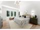 A serene main bedroom with a vaulted ceiling, large windows, a cozy seating area, and elegant furnishings at 20000 Schooner Dr, Cornelius, NC 28031
