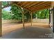 A covered back porch overlooks a large, fenced-in backyard with mature trees and a mulched area at 2033 Camp Greene St, Charlotte, NC 28208