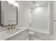 Modern bathroom featuring a combination tub and shower, a vanity and a round mirror at 2033 Camp Greene St, Charlotte, NC 28208
