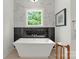 Modern bathroom with a sleek soaking tub, marble accent wall, and bright window view at 2033 Camp Greene St, Charlotte, NC 28208