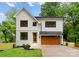 Charming two-story home with white board and batten siding, black framed windows, and a stained wood garage door at 2033 Camp Greene St, Charlotte, NC 28208