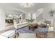 Bright living room featuring an open floor plan with hardwood floors, modern lighting, and a stylish area rug at 2033 Camp Greene St, Charlotte, NC 28208