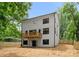 A two-story home shows off it's back exterior with a small deck and partially fenced backyard at 2033 Camp Greene St, Charlotte, NC 28208