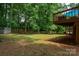 Green backyard with a view of the deck, surrounded by mature trees offering ample shade and privacy at 2298 Wintercrest Dr, Rock Hill, SC 29732