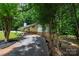 Exterior side view of home with mature trees, gravel driveway, and backyard firepit at 2298 Wintercrest Dr, Rock Hill, SC 29732