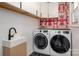 This laundry room includes a modern sink, front load washer and dryer, and graphic accent wall at 2298 Wintercrest Dr, Rock Hill, SC 29732