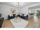 Bright living room featuring hardwood floors, modern lighting, comfortable blue sofas, and open layout to the kitchen at 2324 Brookview Ct, Rock Hill, SC 29732