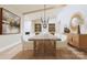 Bright dining room with a long wooden table, white chairs, and decorative lighting fixtures and mirror at 2413 Cross Country Rd, Charlotte, NC 28270