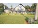 Inviting Tudor-style home with stone detailing and a picturesque landscaped front lawn and garden at 2413 Cross Country Rd, Charlotte, NC 28270