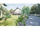 Elegant Tudor-style home surrounded by lush landscaping and mature trees along a private drive at 2413 Cross Country Rd, Charlotte, NC 28270