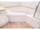 Close up of a large, corner soaking tub with tile surround and chrome fixtures at 3814 Misty Glen Ct, Matthews, NC 28105