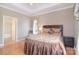 Comfortable bedroom featuring a tray ceiling, bedside table, and access to bathroom at 3814 Misty Glen Ct, Matthews, NC 28105
