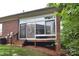 View of the rear exterior of the home featuring a screened porch and wooden stairs at 3814 Misty Glen Ct, Matthews, NC 28105
