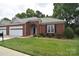 Charming brick home featuring a two-car garage and a well-manicured lawn at 3814 Misty Glen Ct, Matthews, NC 28105