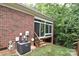 Brick home's exterior showing the screened-in porch, A/C unit, and backyard with trees at 3814 Misty Glen Ct, Matthews, NC 28105