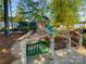 Community playground featuring a play structure, slide, and seating area amid natural landscaping at 401 Lake Club Dr, Rock Hill, SC 29732