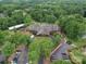 Aerial view of a neighborhood clubhouse surrounded by lush greenery, golf course, and ample parking at 4025 Foxes Trl, Cramerton, NC 28032