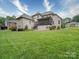 Expansive backyard featuring lush green grass, mature landscaping, and a screened-in porch perfect for outdoor entertaining at 4025 Foxes Trl, Cramerton, NC 28032