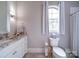 Well-lit bathroom featuring a window, white fixtures, granite countertop and tiled floors for a clean, modern look at 4025 Foxes Trl, Cramerton, NC 28032
