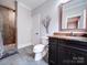 Modern bathroom featuring a standing shower, dark wood cabinets, stone countertop and tiled floors at 4025 Foxes Trl, Cramerton, NC 28032