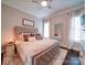 Bedroom featuring a tufted headboard, a decorative mirror, and windows with sheer curtains at 4025 Foxes Trl, Cramerton, NC 28032