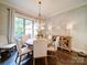 Bright dining room features a round wooden table, upholstered chairs, and decorative wall art at 4025 Foxes Trl, Cramerton, NC 28032