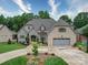 Charming front exterior with stone and brick, a two-car garage, complemented by professional landscaping and a circular driveway at 4025 Foxes Trl, Cramerton, NC 28032
