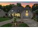 Charming front exterior with stone and brick, a two-car garage, complemented by professional landscaping and a circular driveway at 4025 Foxes Trl, Cramerton, NC 28032