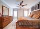 Spacious main bedroom suite featuring a ceiling fan, natural light, wood furnishings and a cozy rug at 4025 Foxes Trl, Cramerton, NC 28032
