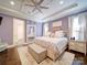 This charming bedroom is lavender with a tray ceiling, a ceiling fan, and plush carpet at 4025 Foxes Trl, Cramerton, NC 28032